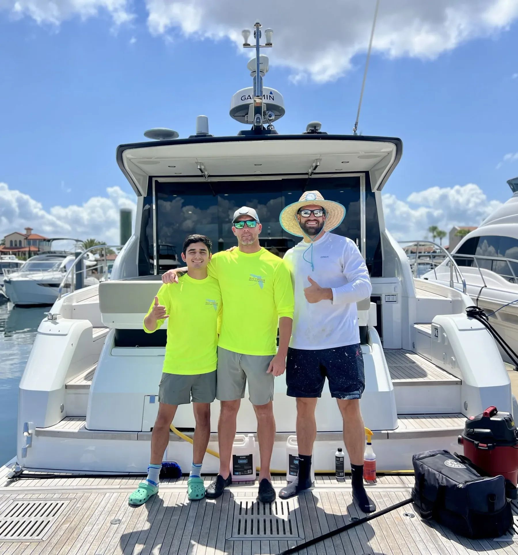 Three of the Bayside crew on the swim platform of a customer's boat at the marina