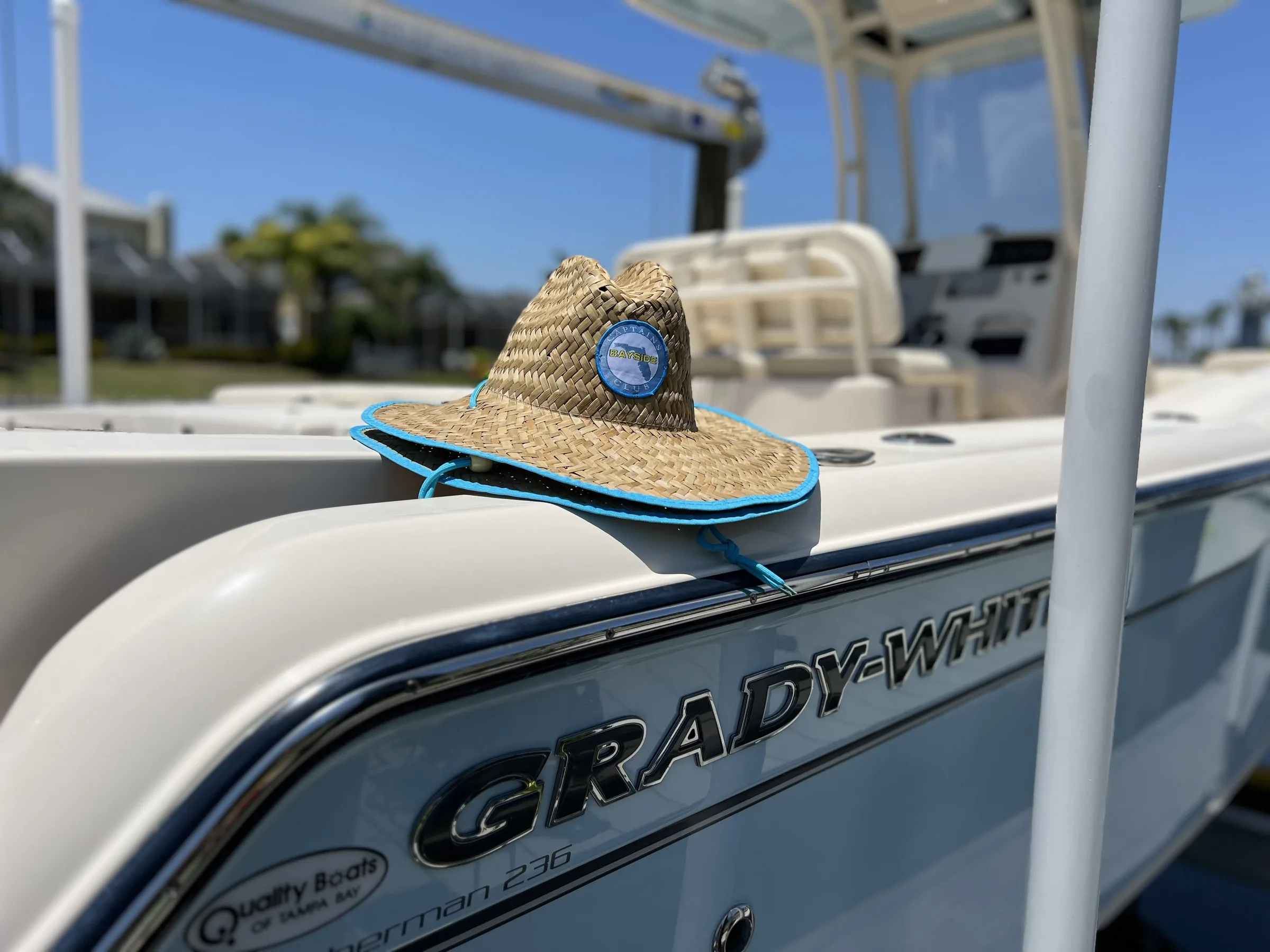 A clean Grady-White center console in the sun with a straw hat resting on the gunwale.
